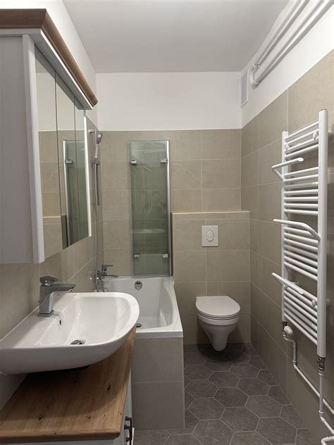 Fürdőszoba bézs és kék burkolólapokkal, beépített tárolókkal