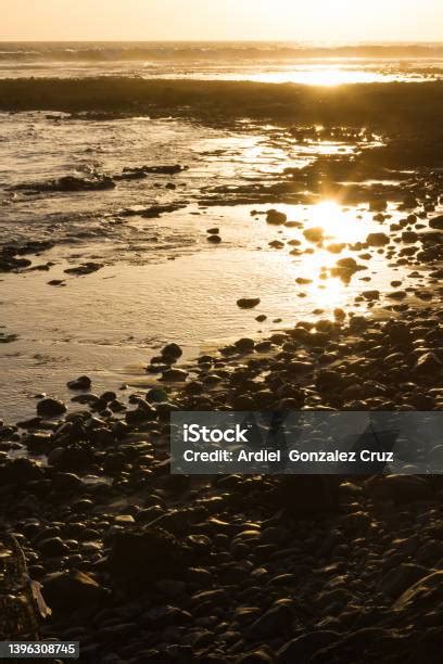 Lábak vízicipőben kavicsos tengerparton